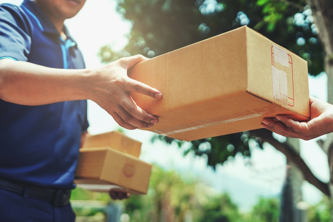 USPS worker handing package to customer