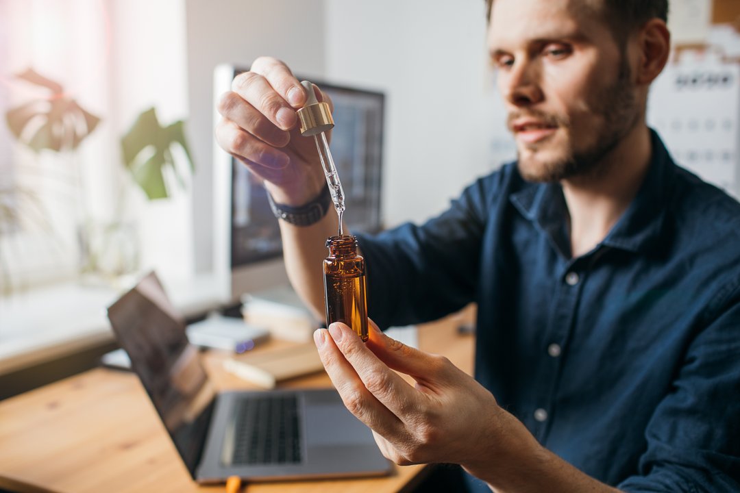 young man using a cannabis tincture oil