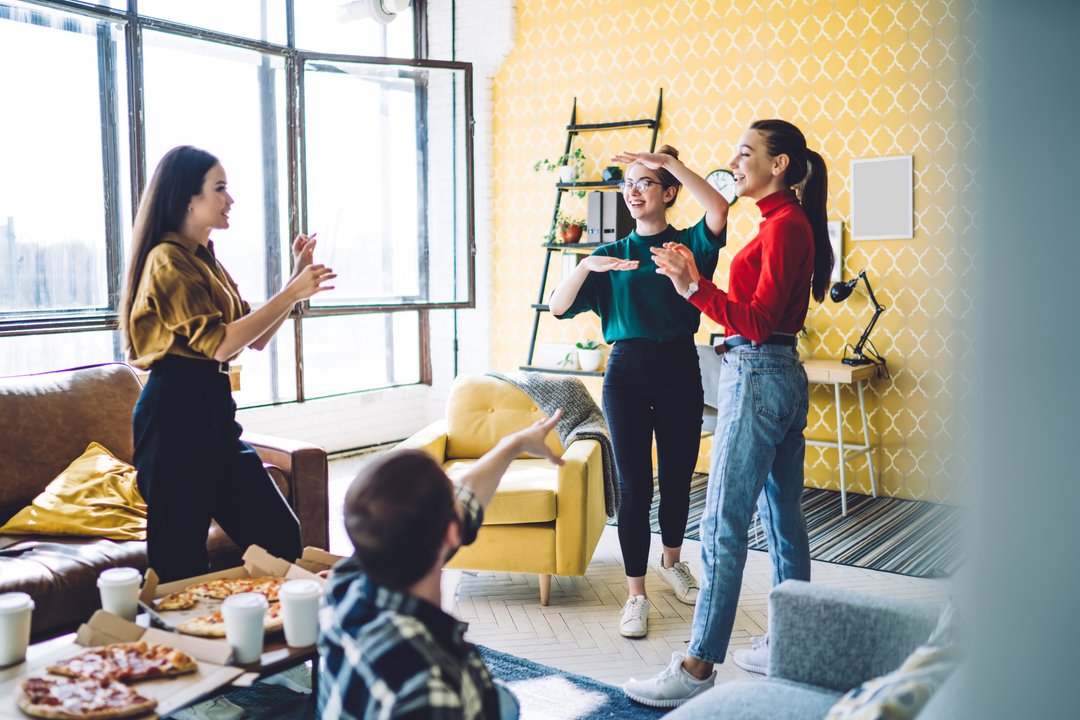 friends playing charades at a house party