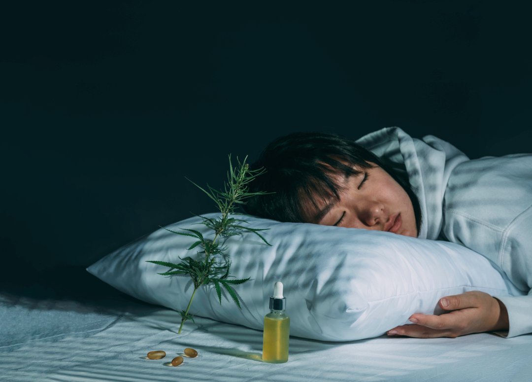 woman falling asleep next to hemp oil and cannabis products