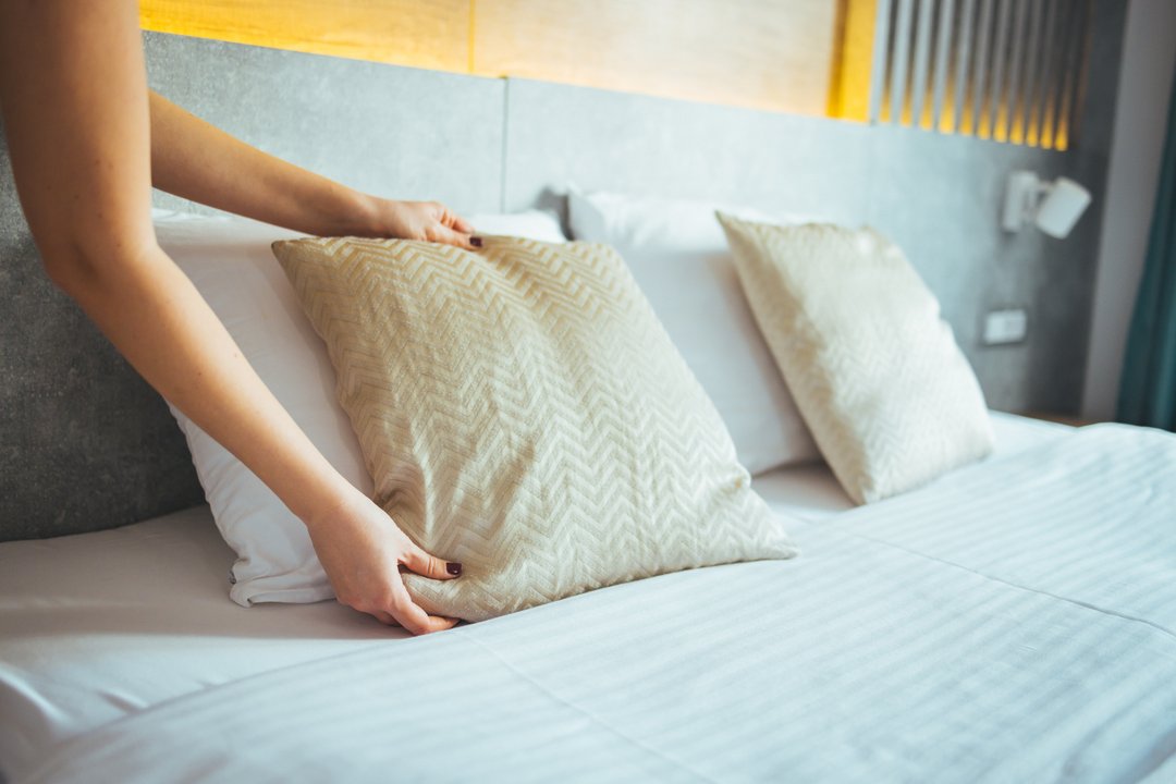 woman fixing her bed