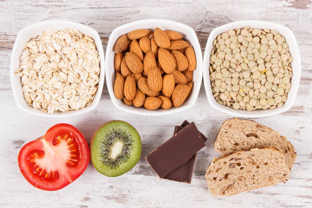 Healthy foods on a table: vegetables, nuts, grains, fruits and chocolate