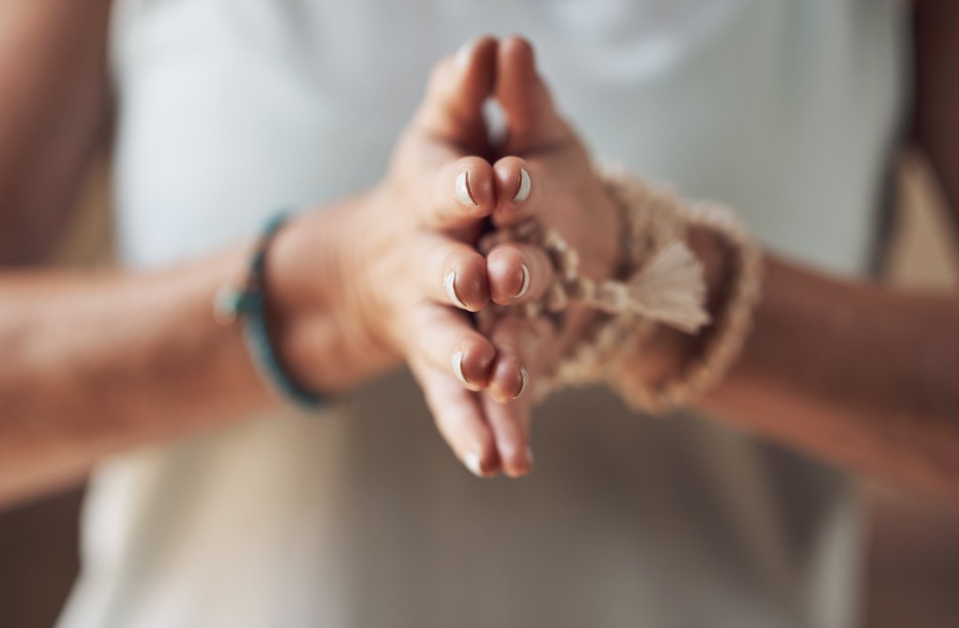 woman holding palms together while meditating