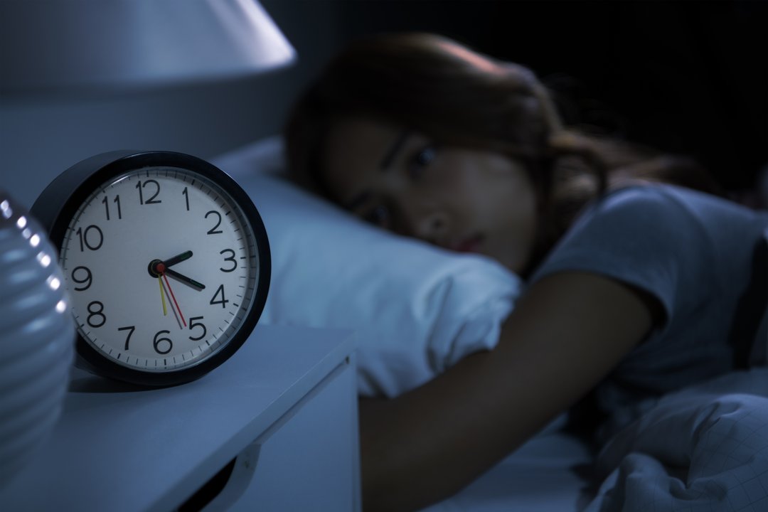 woman staring at her clock because she can't sleep