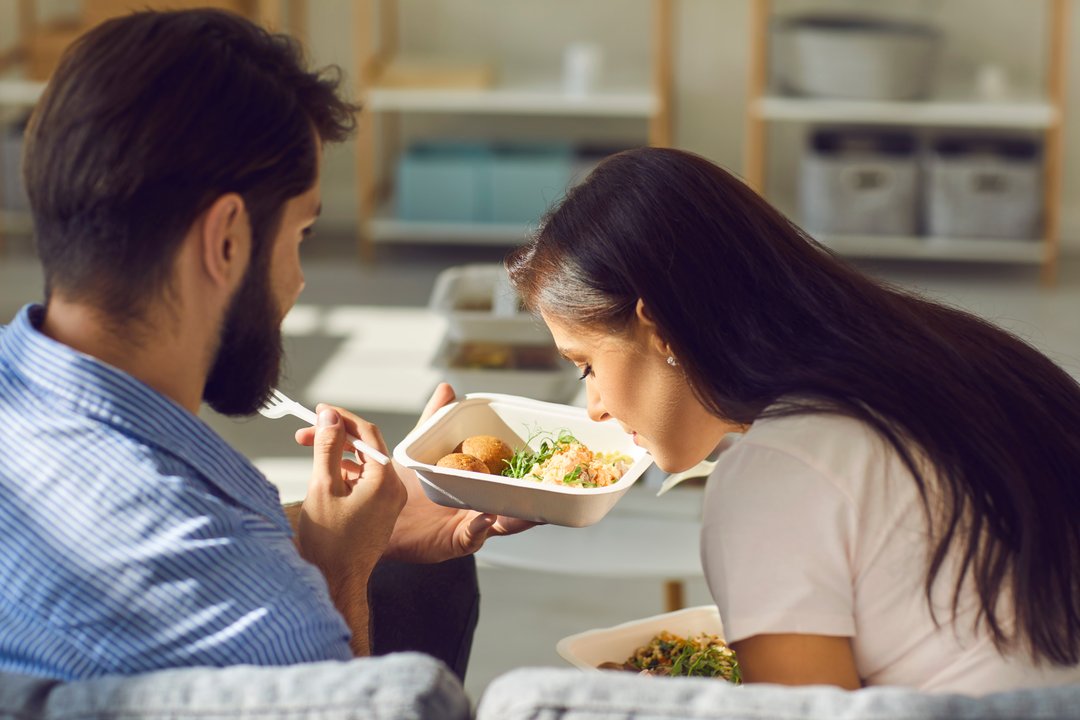 woman and man smelling their takeout food