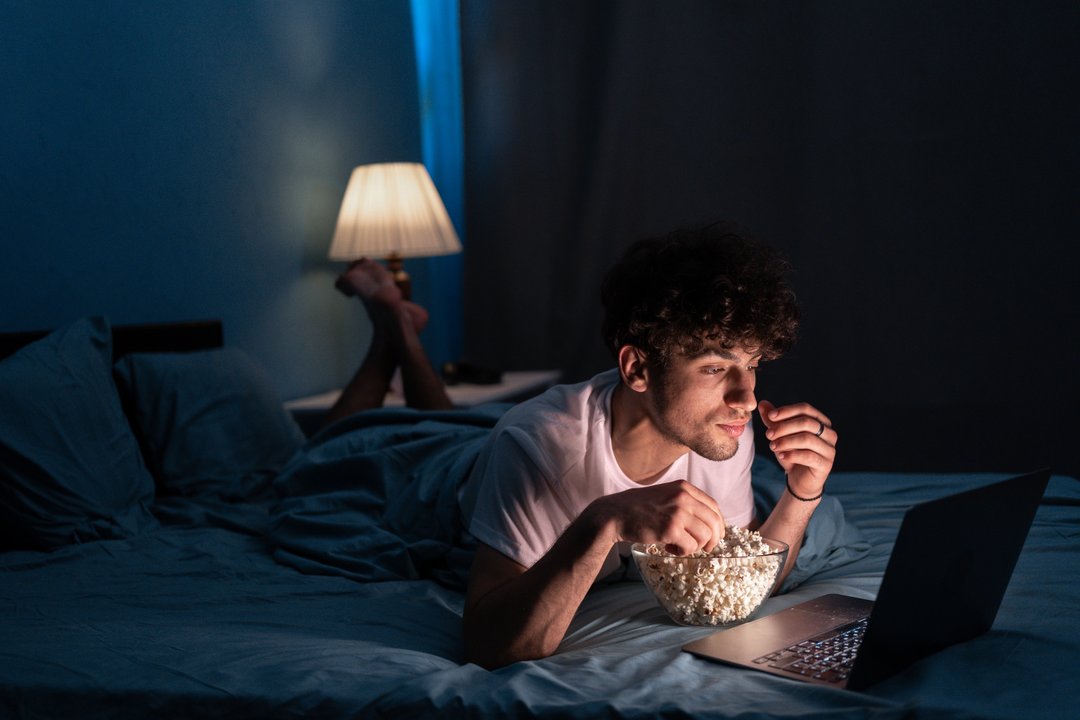 young man snacking unhealthily at bedtime