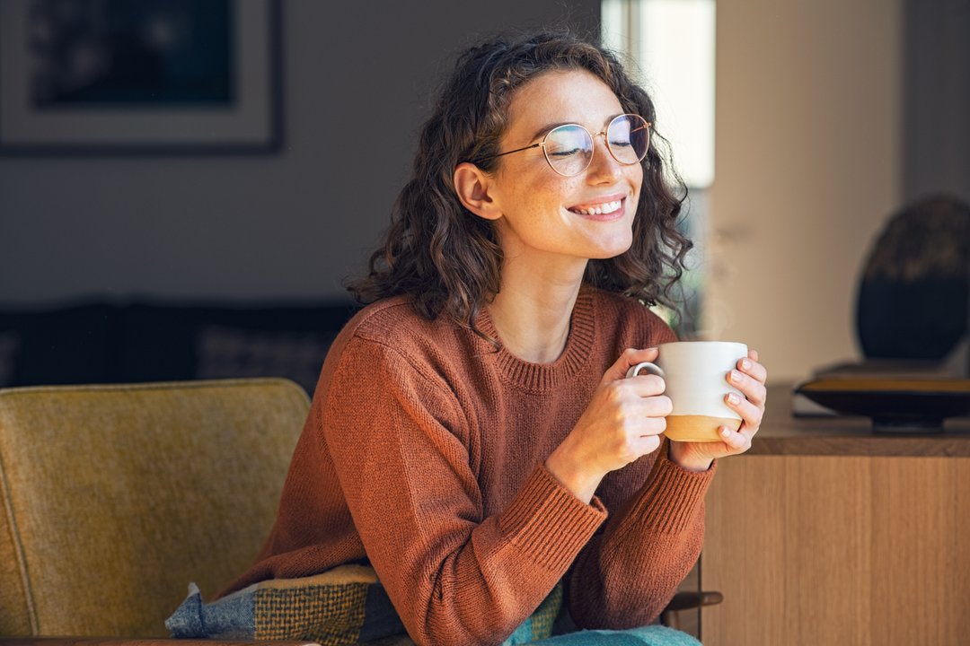 Stress-free woman smiling with adaptogenic herbal tea