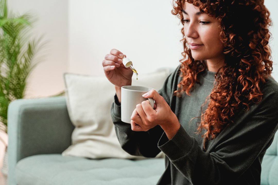 Woman using a tincture to microdose THC.