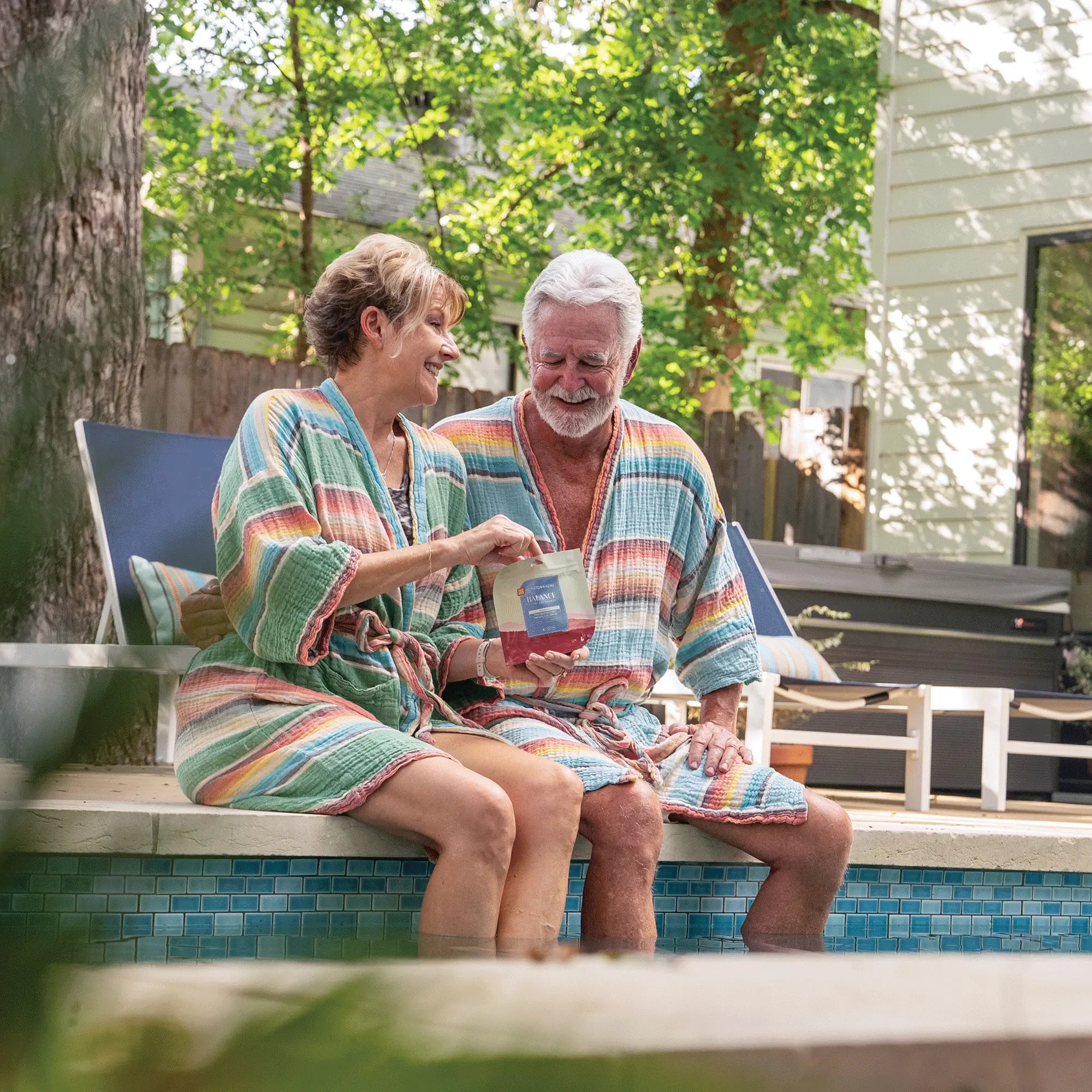 older couple by the pool sharing balance gummies