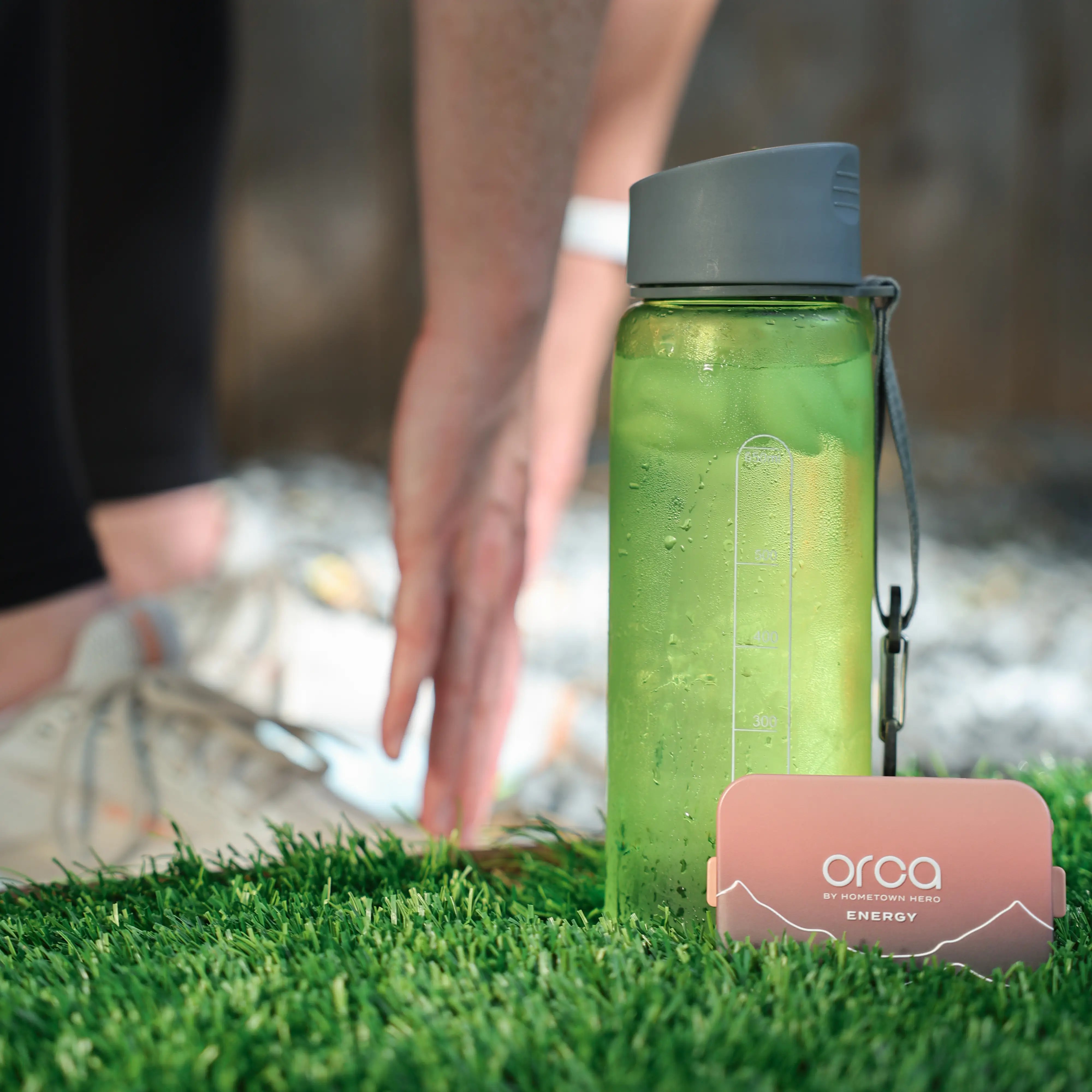 Person stretching next to orca tin and water bottle