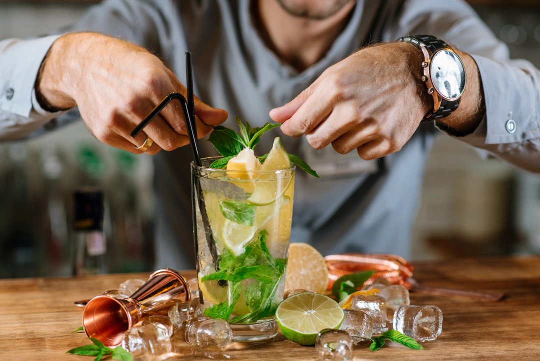 A barista preparing a mojito cocktail