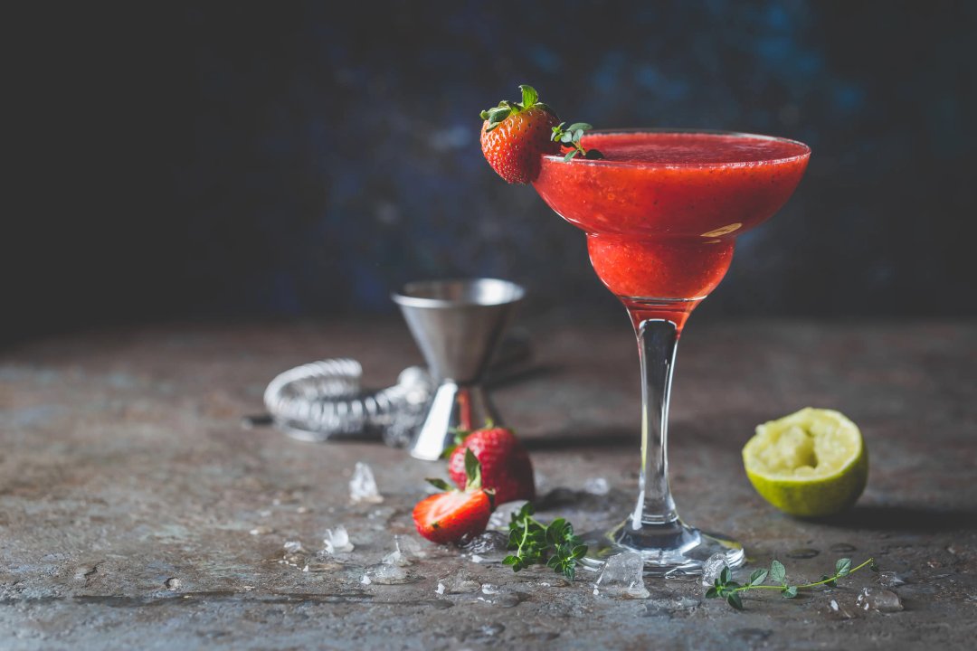 Ice Strawberry alcohol cocktail with lime and rum in a glass