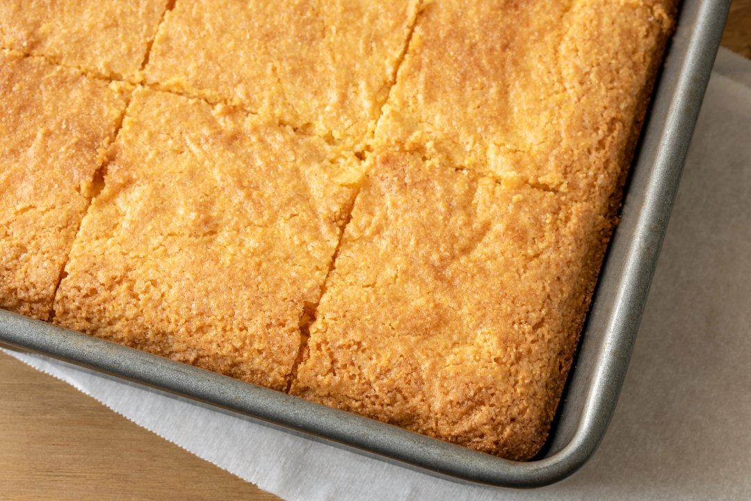 A pan full of cornbread cut evenly into squares