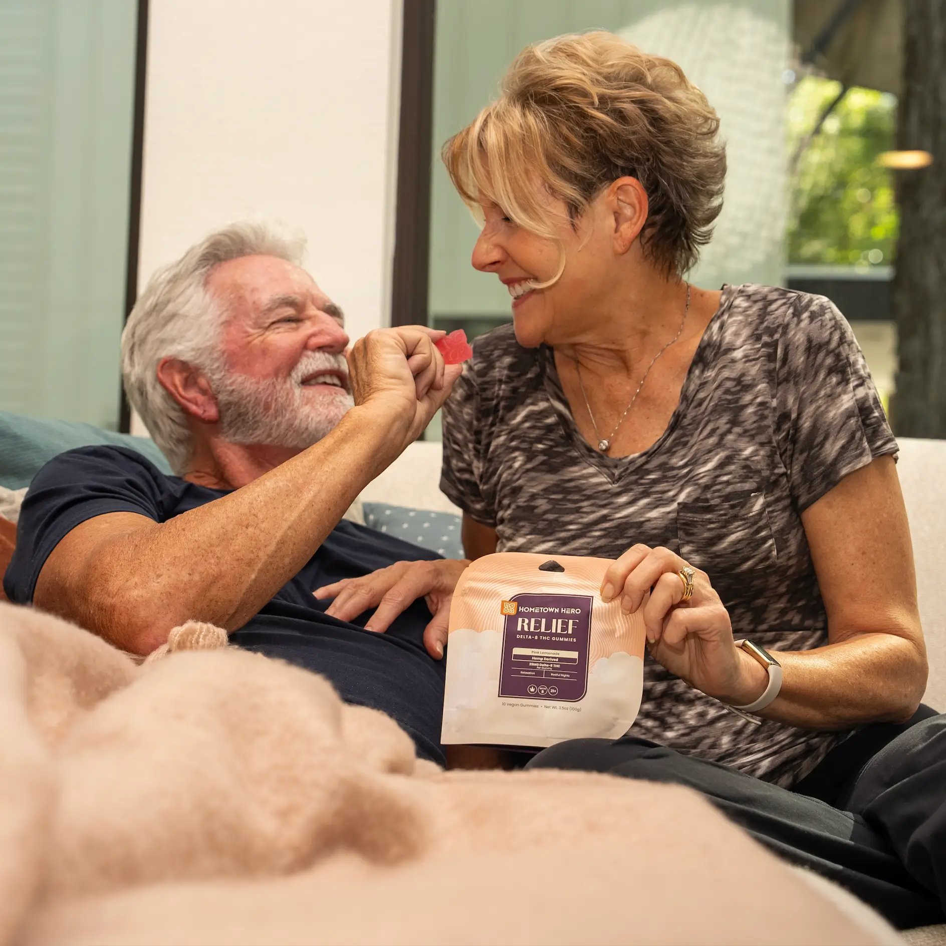 older couple on couch sharing a gummy