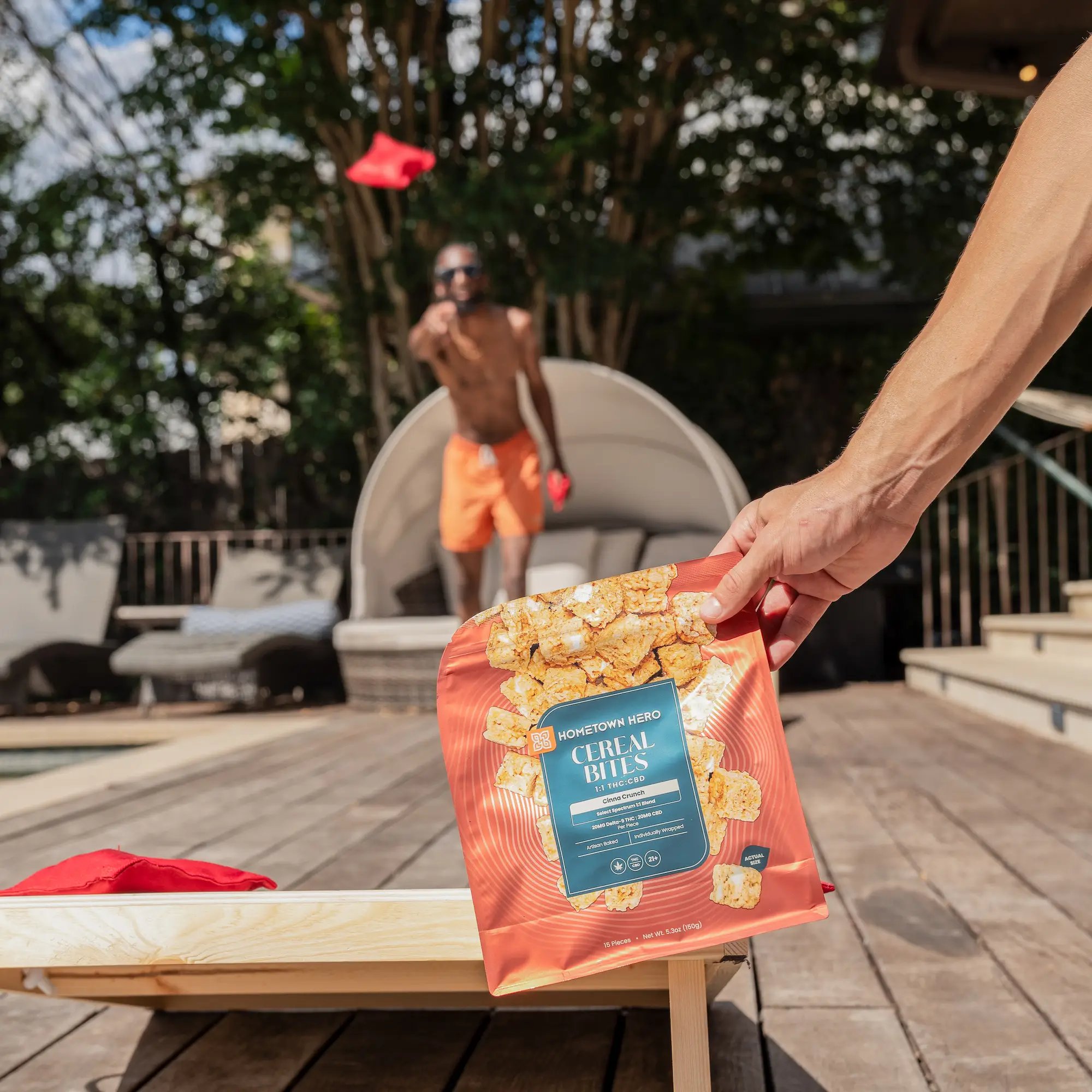 hand holding a bag of cereal squares by the pool