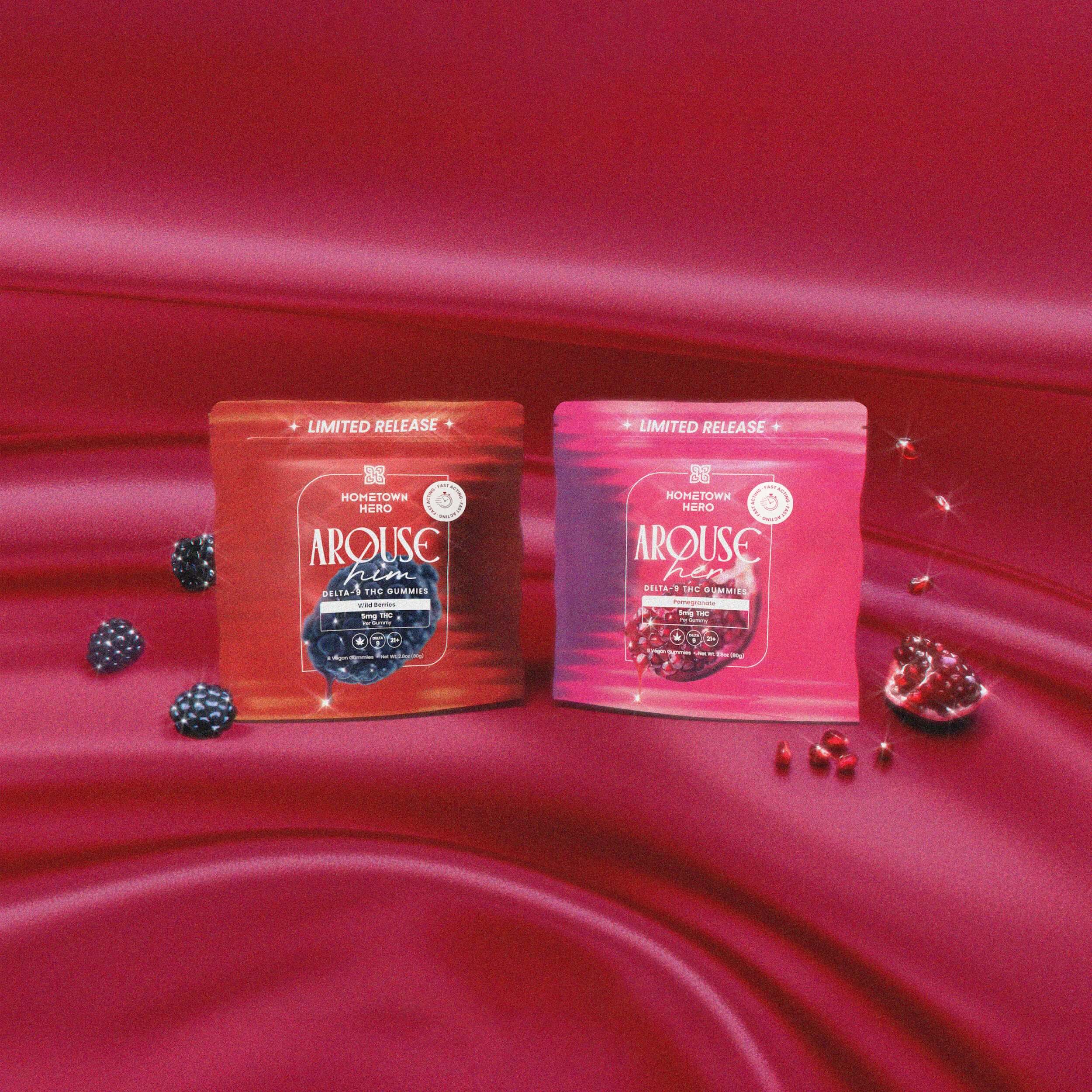 two bags of gummies, one pink and one red, with fruit on silk sheets