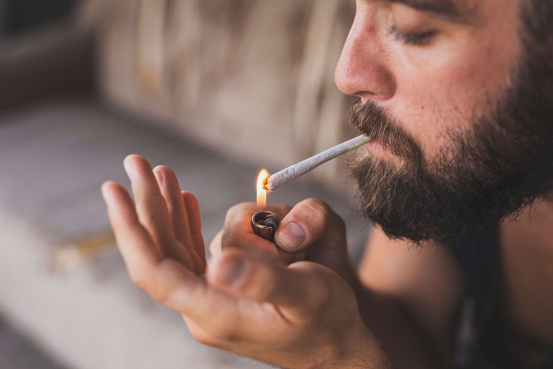 man lighting a blunt