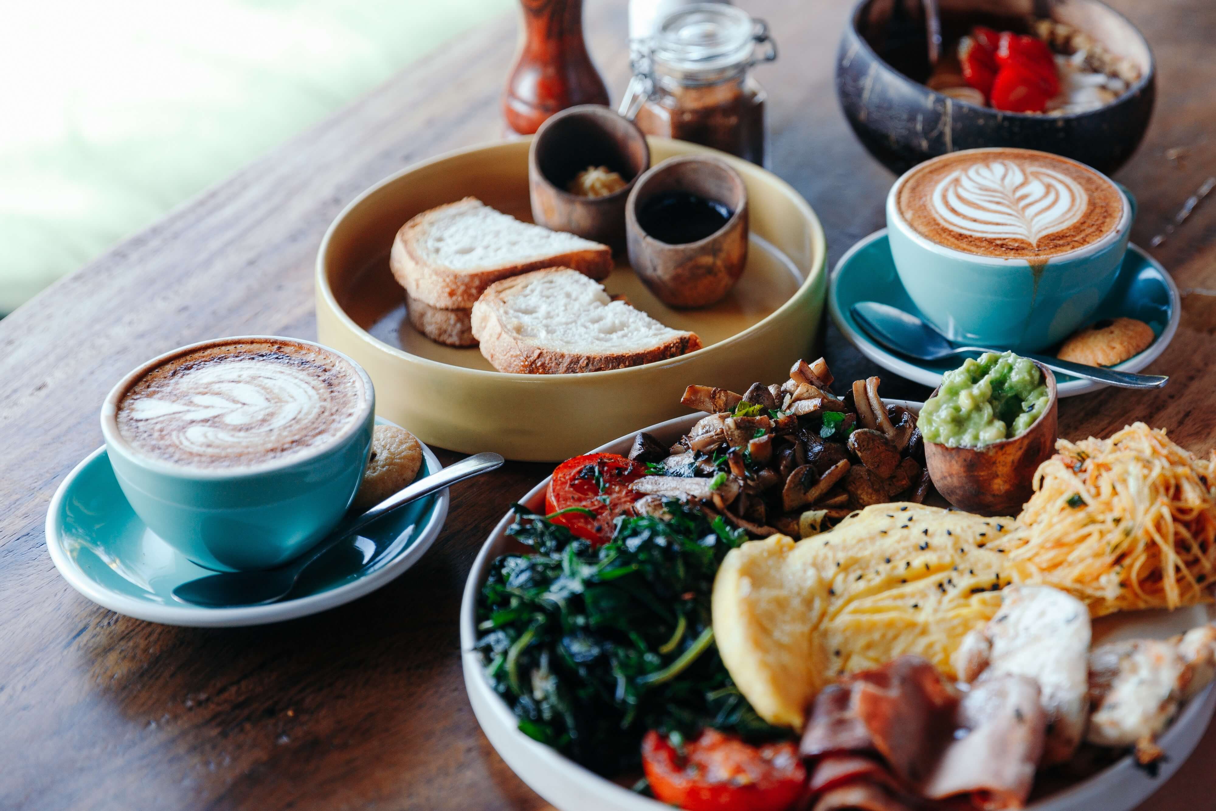 brunch spread of sandwich, coffees, eggs