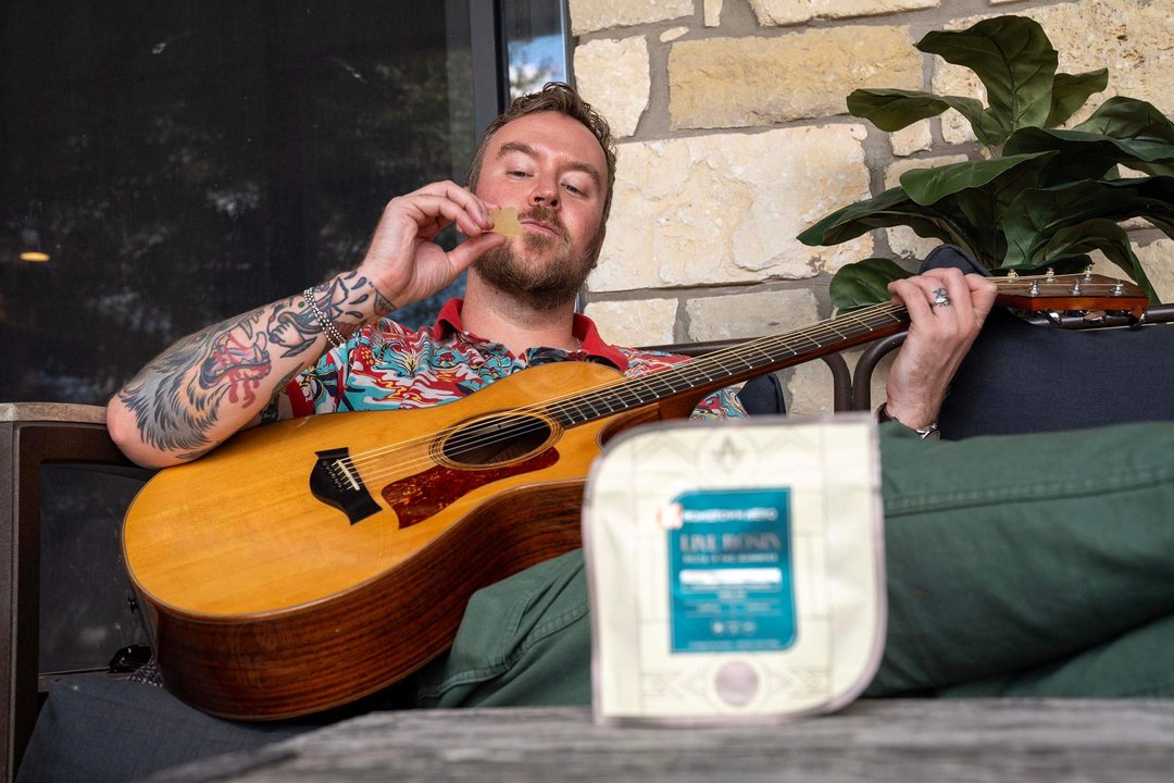 young man looking at a cannabis gummy