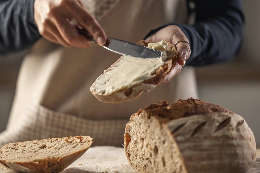 woman spreading cannabutter on freshly baked bread