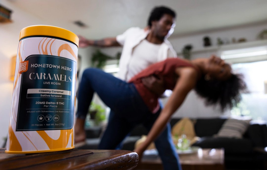 cannabis edibles in the foreground, blurred couple dancing in the background