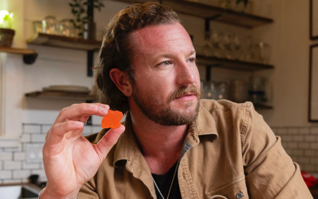 man holding a hometown hero delta-9 gummy in his hand