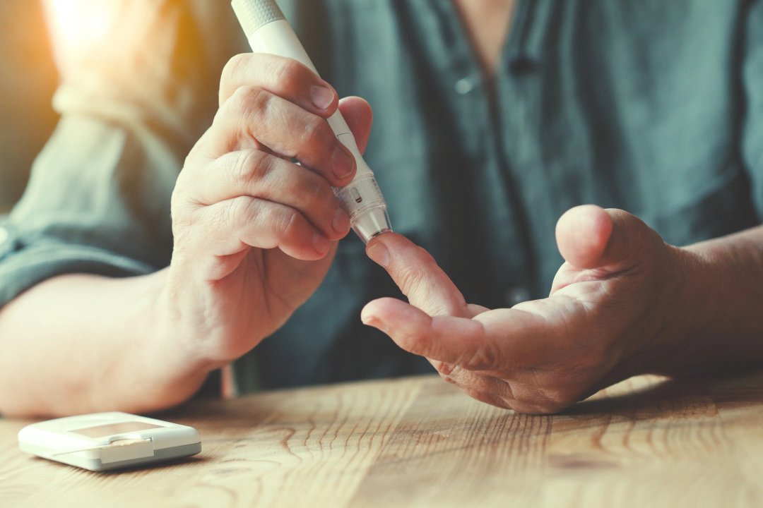 man checking his blood sugar levels using a device