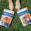 2 bags of calming pet treats with cbd next to paws