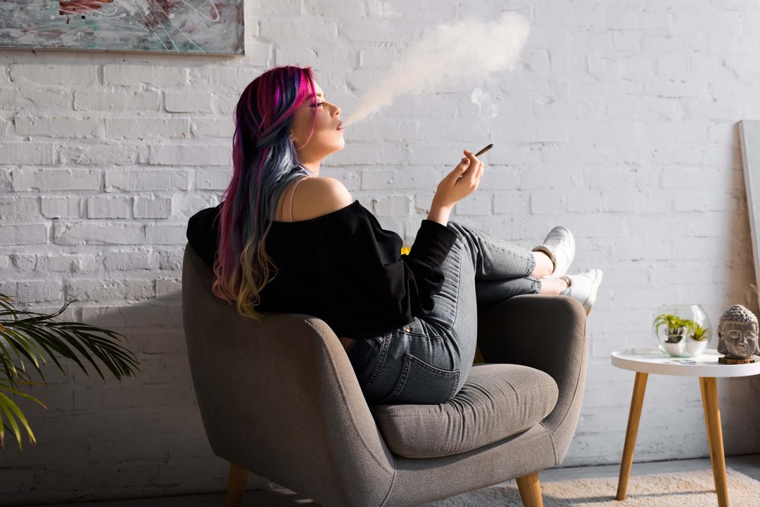 woman exhaling puff of weed smoke