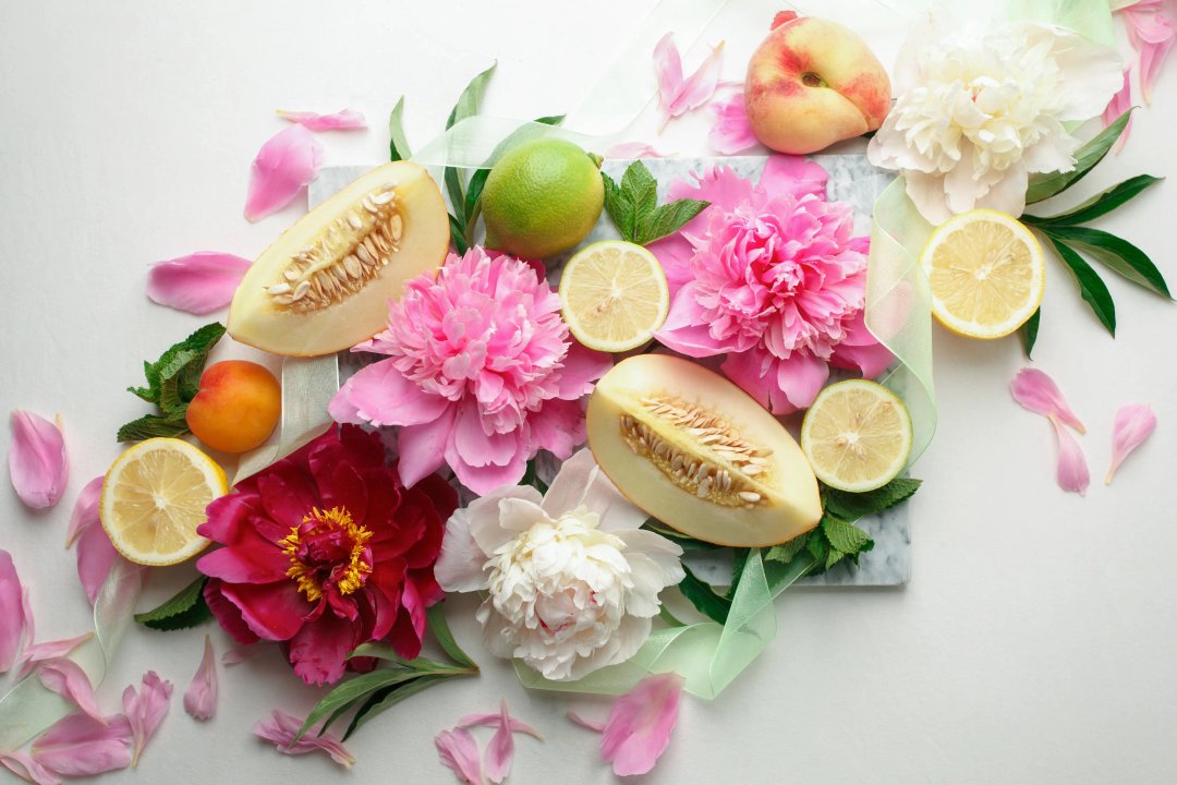 peaches, melons and flowers on a table to indicate fruity and floral aromatic terpenes