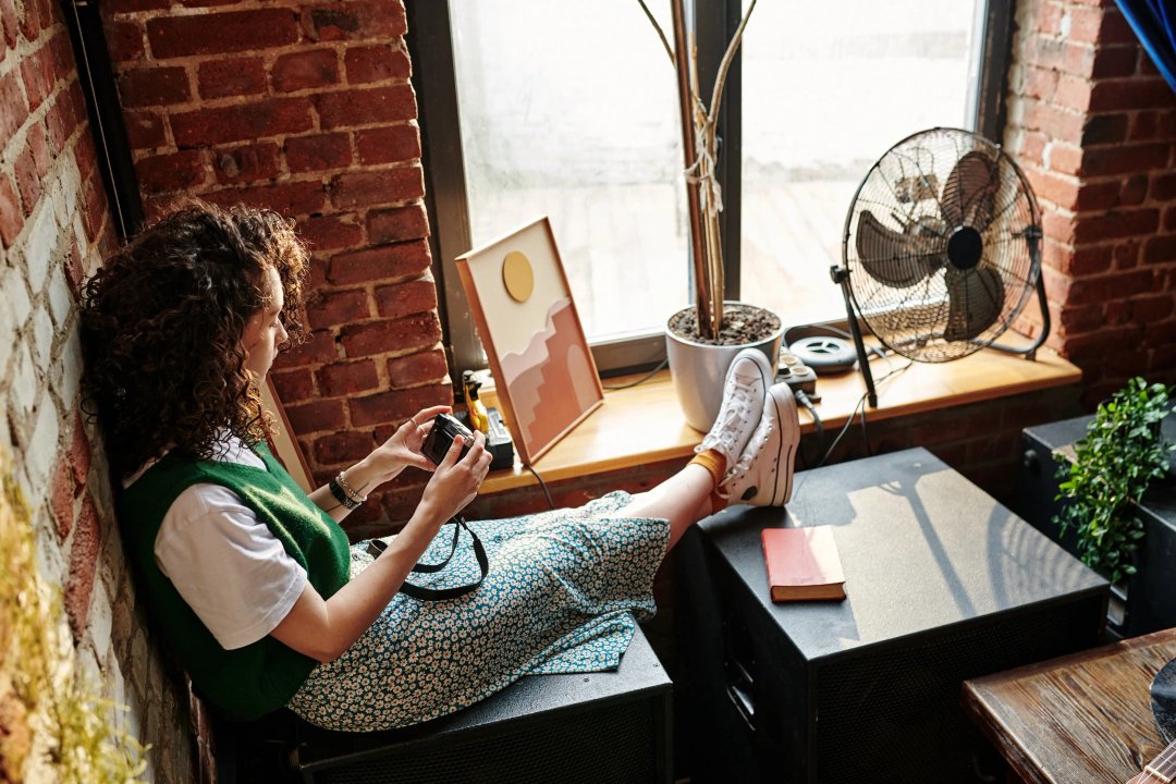 young gen z woman in her room by a warm window with sunlight