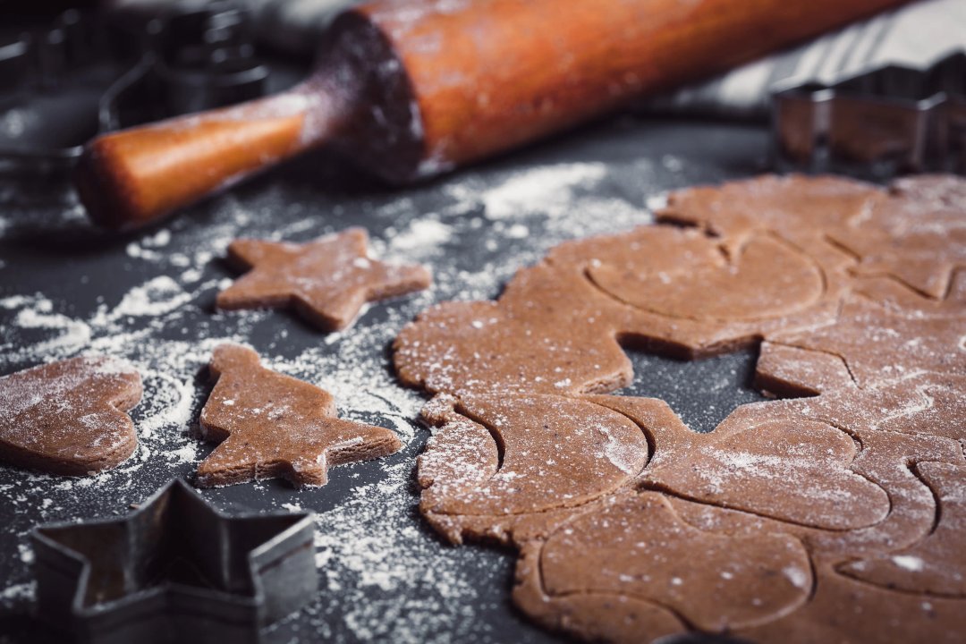 gingerbread dough on a table with flour and cookie cutters