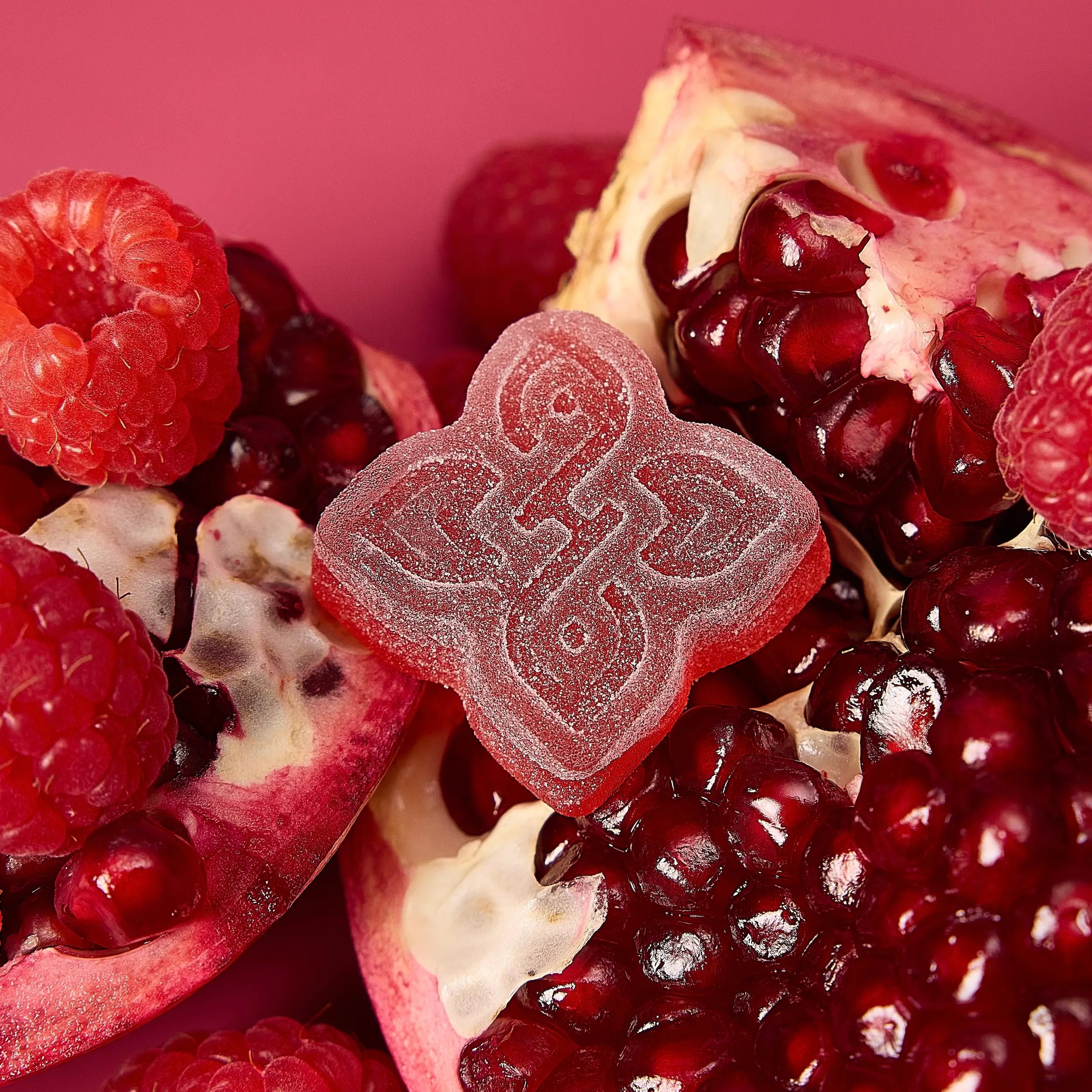 closeup of a gummy with real pomegranate seeds, raspberries