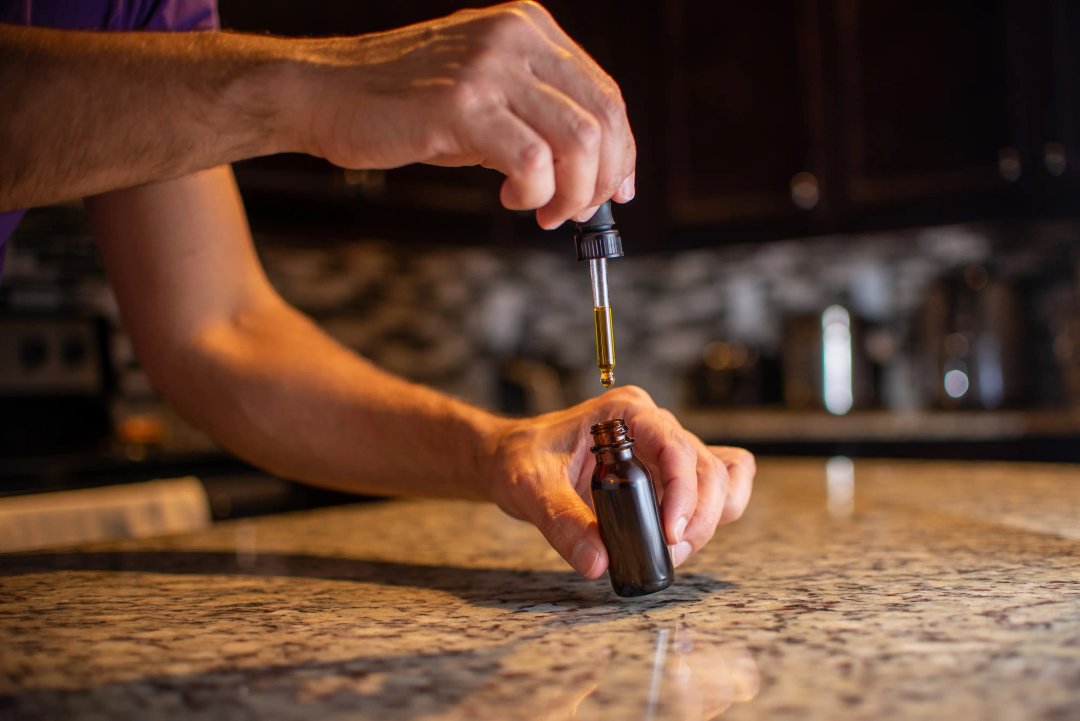 man's hands holding a cannabis tincture