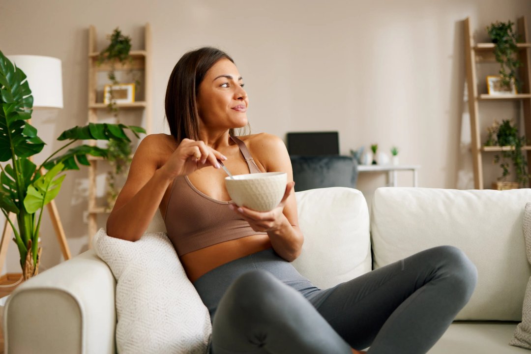 woman enjoying a bowl of healthy low-sugar food on her couch