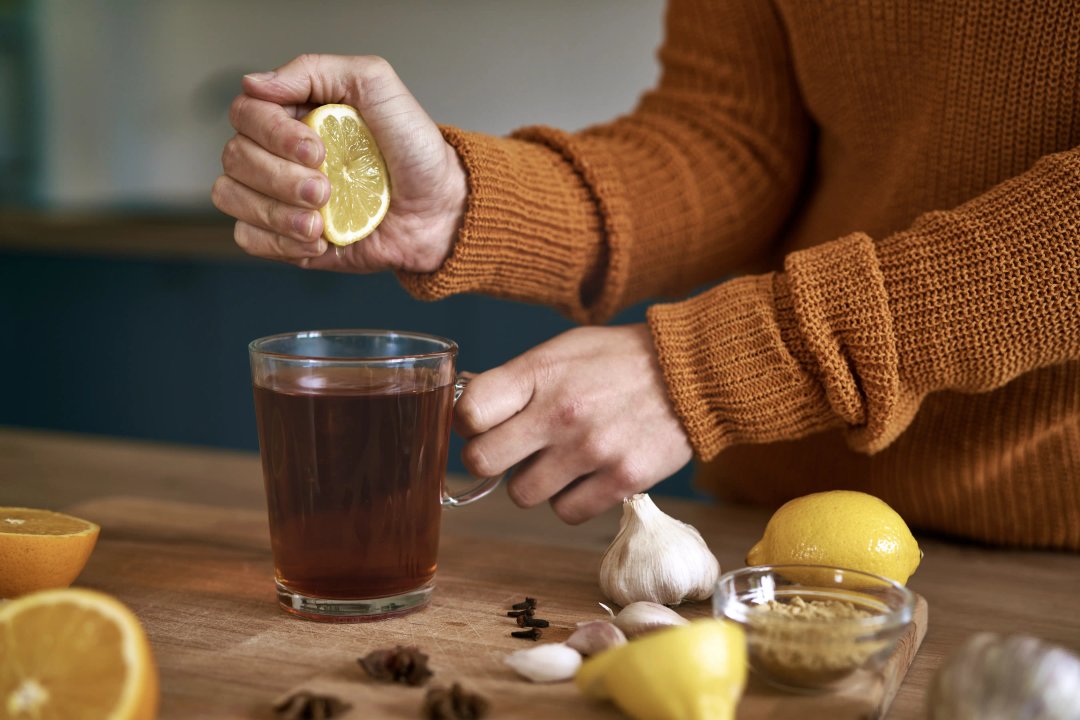 woman squeezing lemon into tea