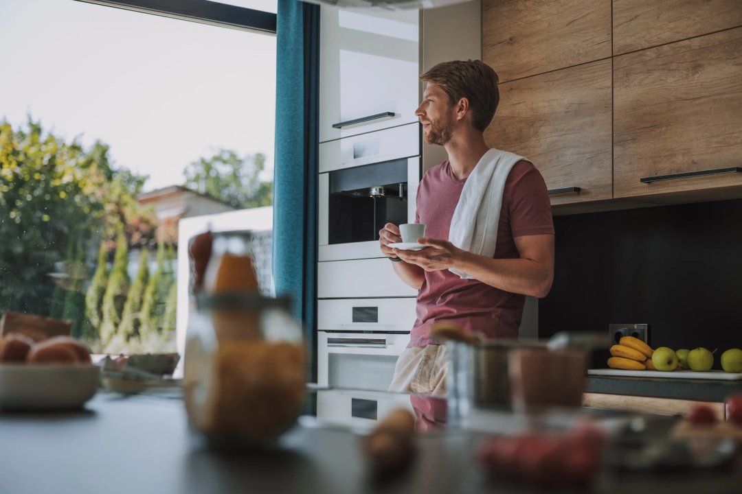 man who abides by a healthy lifestyle drinking coffee in his home