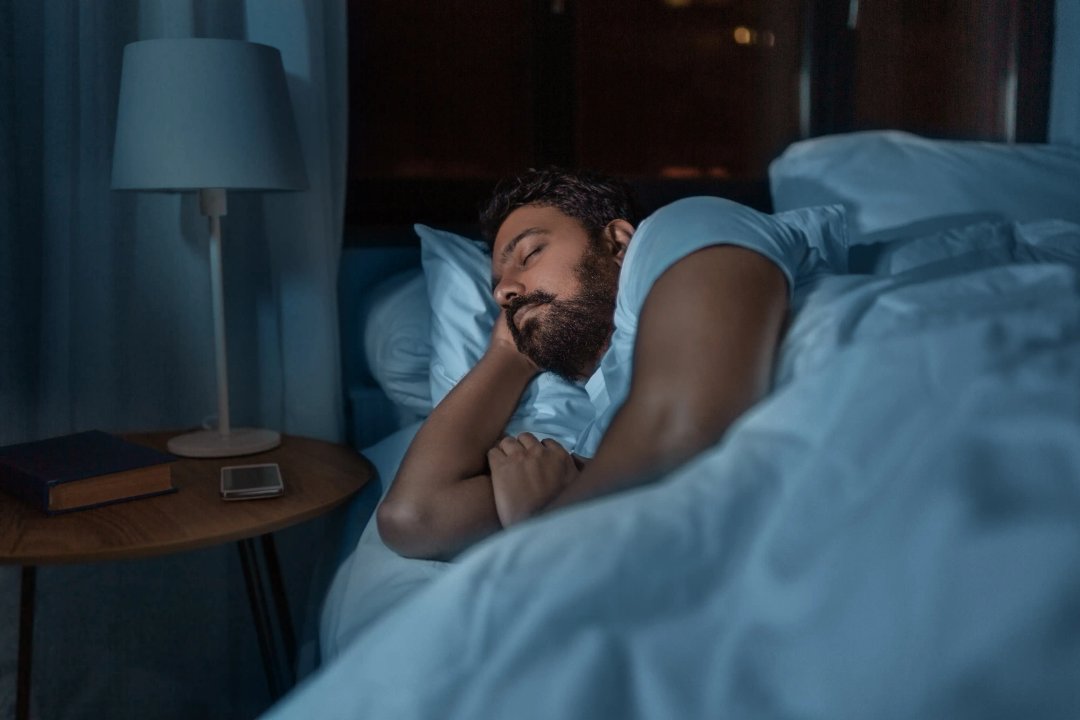 man sleeping peacefully in his bed at night