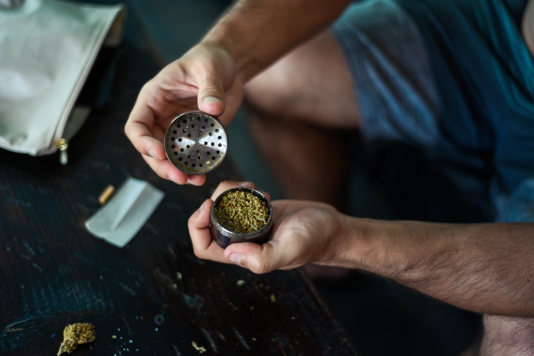 man using herb grinder