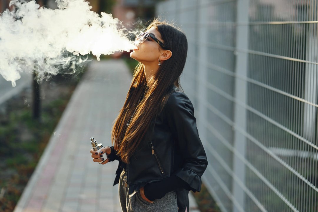 attractive woman vaping outdoors