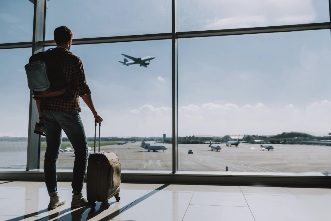 man with his luggage about to depart on a plane