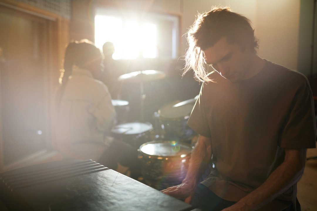 man playing music with friends in his garage