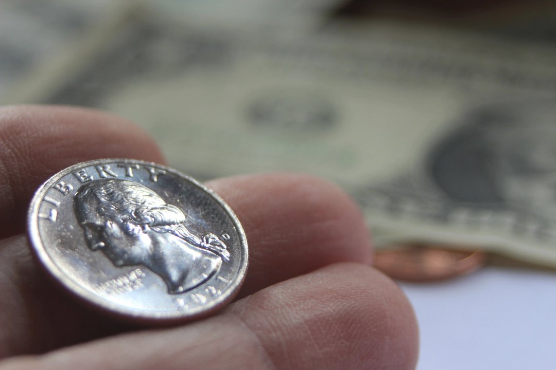 close up of a quarter in someone's hand