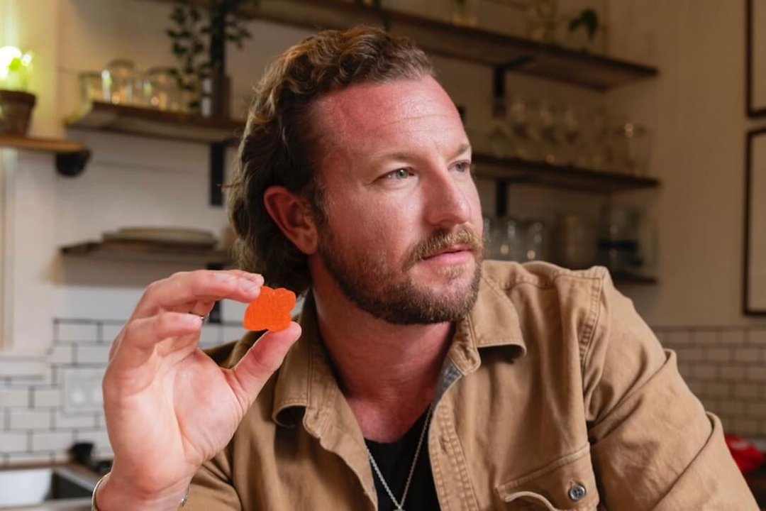 man holding a cannabis infused gummy
