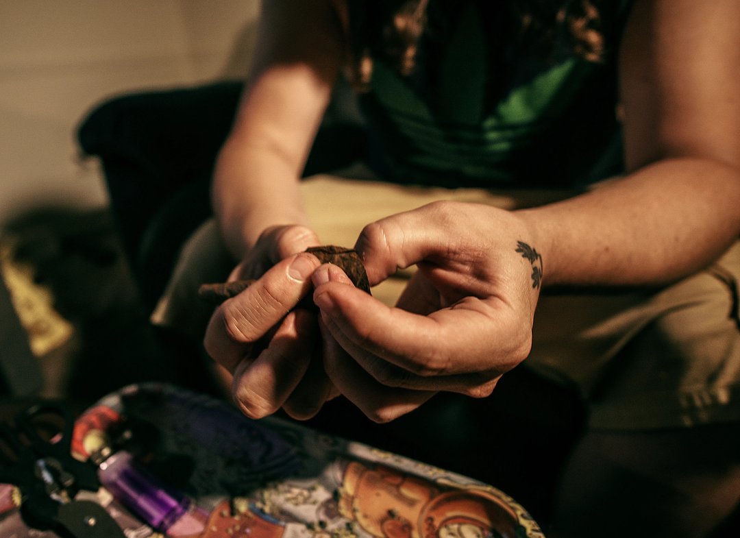 man rolling a blunt