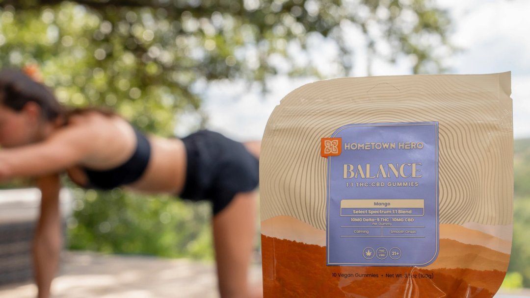 package of balance gummies in the foreground, woman doing yoga in the background