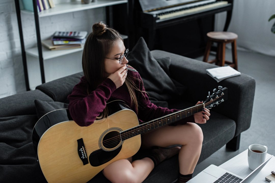 woman smoking a blunt of weed and playing an instrument