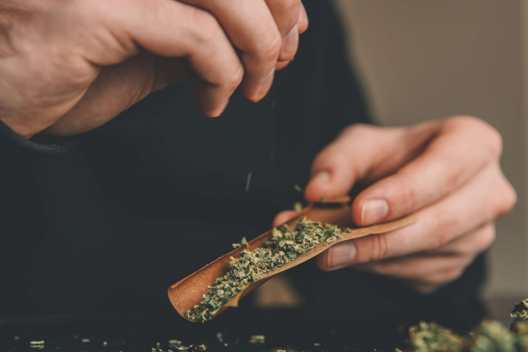 man rolling a blunt