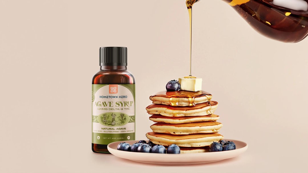 pouring THC-infused agave syrup on a stack of pancakes with blueberries on a plate.