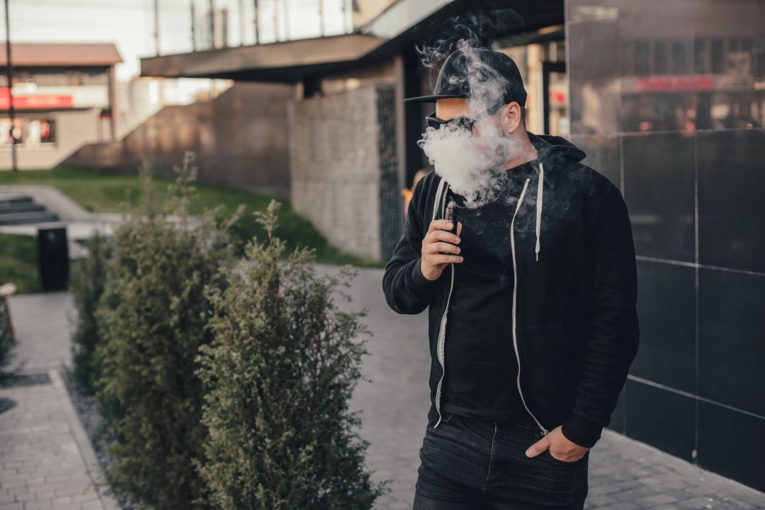 young man vaping in an urban location